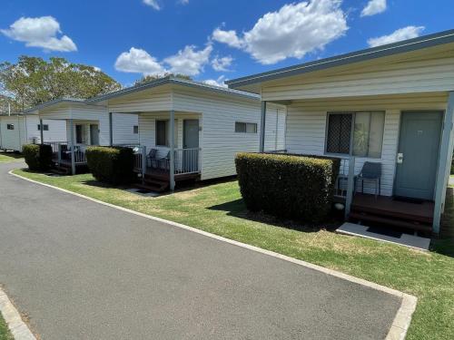 a row of modular homes with bushes in front of them at Chinchilla Motor Inn in Chinchilla