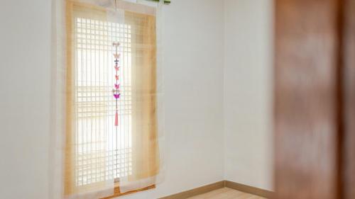 ventana en una habitación con cortina en Gangneung ggabinejip hanok pension, en Gangneung