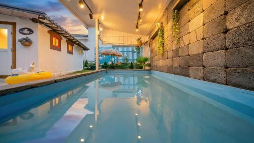 una piscina en una casa con luces encendidas en Gangneung ggabinejip hanok pension, en Gangneung