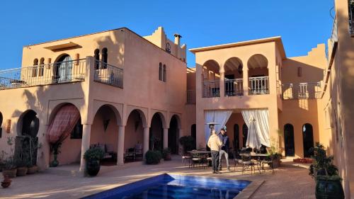 塔鲁丹特Riad Jardin des Orangers的站在房子庭院中的男人