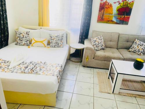 a small living room with a bed and a couch at Tash Studios in Diani Beach