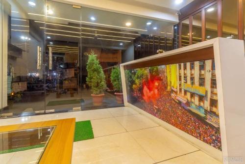 een groot raam in een gebouw met een kamer vol planten bij Hotel Girishankara in Indore