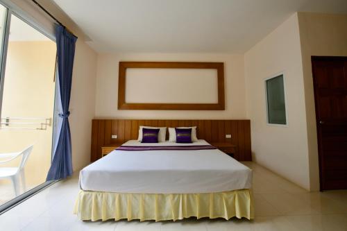 a bedroom with a bed and a large window at Ashiraya hostel in Kata Beach