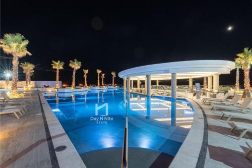 a pool at night with chairs and palm trees at Encantame Soleil New Resort 3rd Floor Studio in Playa Encanto