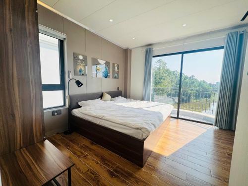 a bedroom with a large bed and a large window at Homestay Lion in San Cap