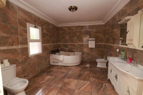 a bathroom with a toilet and a sink and a tub at Complejo Caribe in Monte Alen