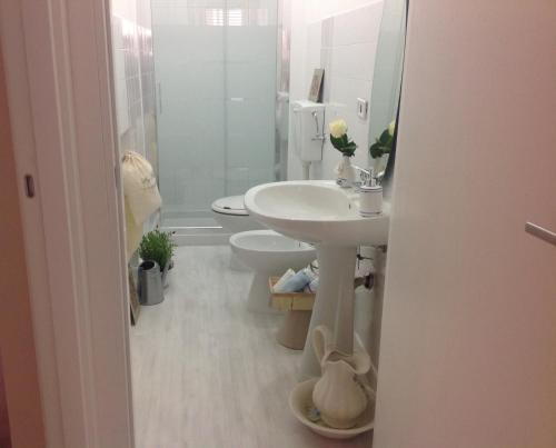 a white bathroom with a sink and a toilet at Casa Pinù in San Michele di Ganzaria