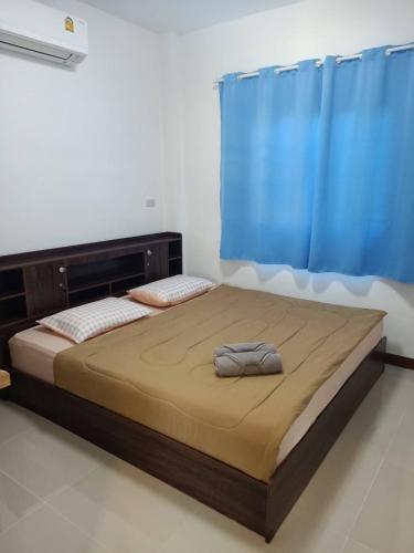 a bedroom with a bed with a blue curtain at Keerana Villa in Uttaradit