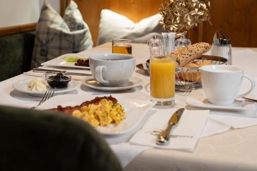 a table topped with plates of food and drinks at Hotel zum Hirschen Zell am See in Zell am See
