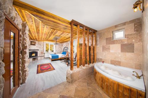 een grote badkamer met een bad en een open haard bij Moonlight of Cappadocia in Uchisar
