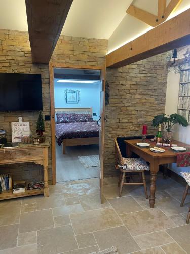 a living room with a table and a bedroom at Tawny Lodge, Evesham Nr Cotswolds in Evesham
