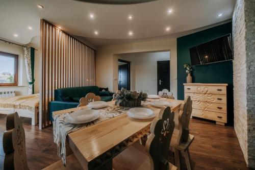 a dining room with a table and a couch at Willa Sulejowka in Poronin