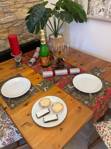a wooden table with plates of food on it at Tawny Lodge, Evesham Nr Cotswolds in Evesham