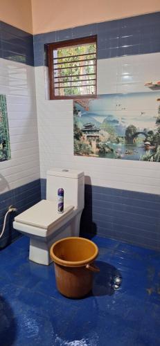 ein Badezimmer mit WC und blauem Boden in der Unterkunft Pearl farmstay in Kushālnagar