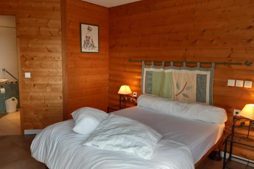 a bedroom with a large bed in a log cabin at Appartement les Coquelicots Super Besse in Besse-et-Saint-Anastaise