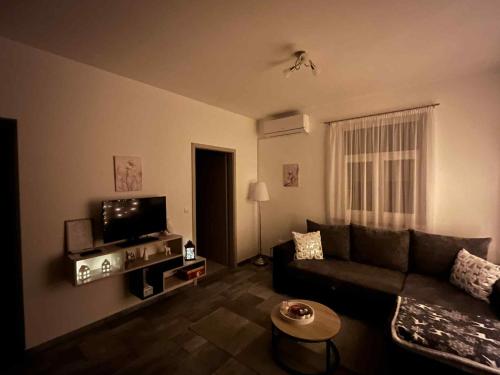 a living room with a couch and a tv at Vadvirág Vendégház Gárdony in Gárdony