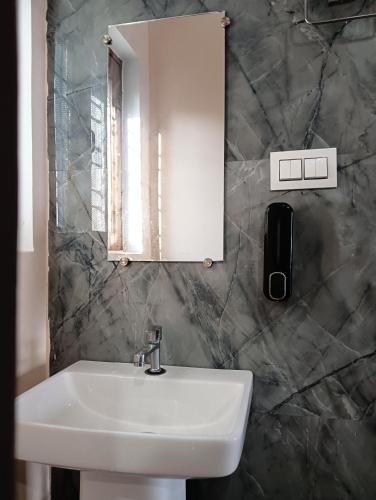 a bathroom with a white sink and a mirror at Geetanjali Palace Hotel & Restaurant in Rudraprayāg