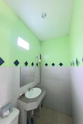 ein weißes Badezimmer mit Waschbecken und Toilette in der Unterkunft Nasa Hotel in Phuket