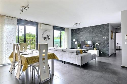 a living room with a couch and a table at FAA'mily Home, 3 bedrooms, meublé de tourisme 4 étoiles in Offemont