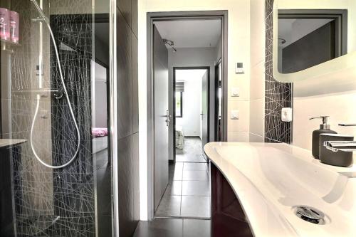 a bathroom with a sink and a shower at FAA'mily Home, 3 bedrooms, meublé de tourisme 4 étoiles in Offemont