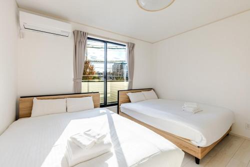 En eller flere senge i et værelse på Ganadan福岡南