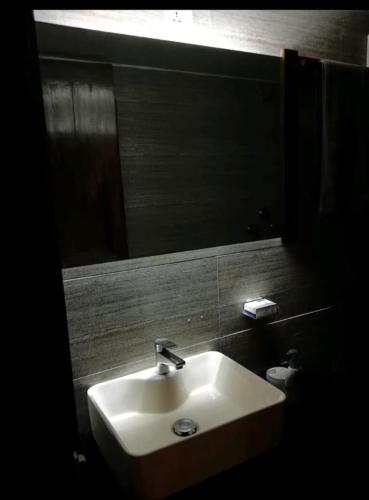 un bagno con lavandino e specchio di Edu Nibas a Dhaka