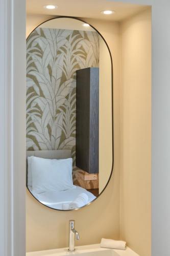 a mirror over a sink with a bed in a room at Jorisz Apartments in Haarlem