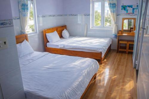 two beds in a small room with two windows at Hoàng Thiện Homestay đảo Phú Qúy in Cu Lao Thu