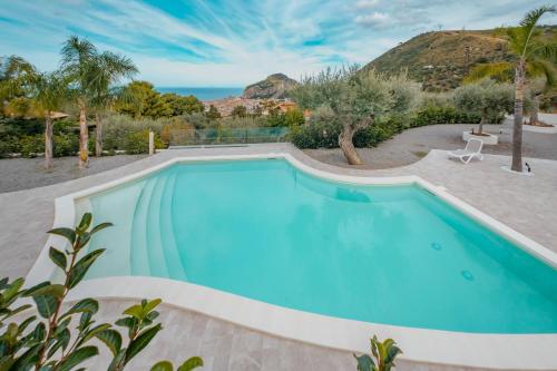 ein Swimmingpool mit einem Berg im Hintergrund in der Unterkunft Villa Teresa in Cefalú