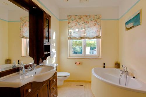 a bathroom with a tub and a sink and a toilet at House Moreda by Istrialux in Vodnjan