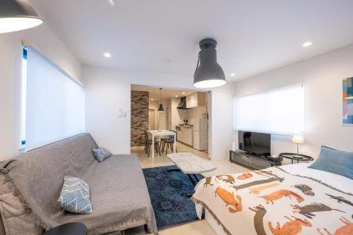 a living room with a bed and a couch at Fuku no Yado 難波 京セラドーム直通15分 USJ 大阪 甲子園20分 in Osaka