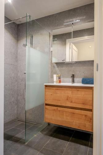 a bathroom with a sink and a shower with a mirror at Charming Vacation Home Spier in Spier
