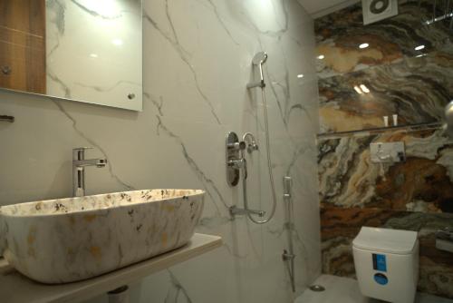 ein Badezimmer mit Steinwaschbecken und Dusche in der Unterkunft Hotel Sonali Golden Palace in Bhubaneshwar