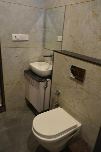 een badkamer met een wit toilet en een wastafel bij Mahi Baagh Resort in Pāli
