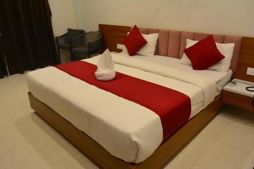 een slaapkamer met een groot bed met rode en witte kussens bij Mahi Baagh Resort in Pāli