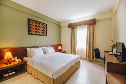 Ένα ή περισσότερα κρεβάτια σε δωμάτιο στο Hotel Luwansa Palangkaraya