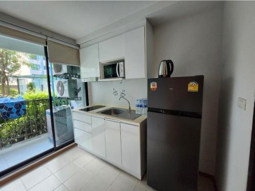 eine kleine Küche mit Kühlschrank und Spüle in der Unterkunft cen807 in Phuket