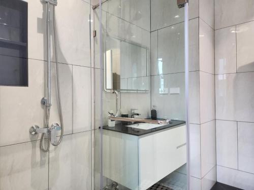 een witte badkamer met een wastafel en een douche bij WEG Title Legendary in Bang Tao Beach
