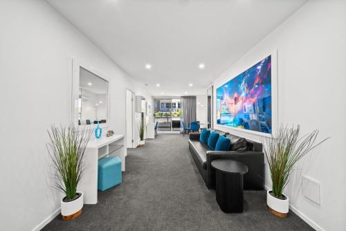 a living room with a couch and a tv at 2BR Apt Gungahlin Square Luxe Super Central Wifi Wine Secure Parking in Canberra