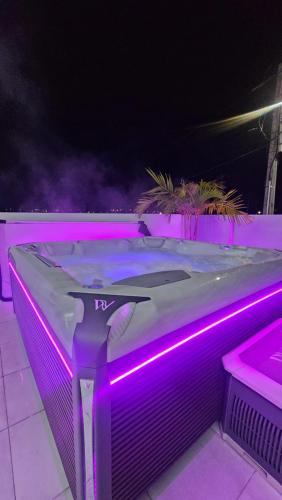 a hot tub with purple lights on a patio at Recomeçar Guesthouse in Santa Cruz