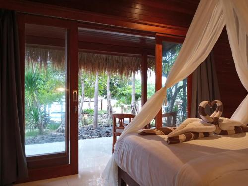 una camera con letto, amaca e finestra di The Kudi a Nusa Lembongan