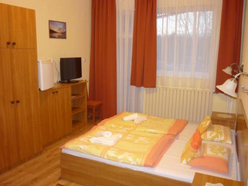 una camera da letto con un letto con una coperta gialla sopra di Hableány Hotel a Tiszafüred