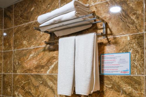 un tas de serviettes accrochées au mur d'une salle de bain dans l'établissement Relax Beach Hotel, à Alanya