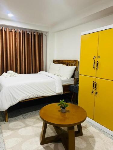 a hotel room with two beds and a table and yellow cabinets at Studio Room in Zanzibar City