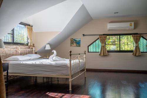 a bedroom with a bed with a swan on it at Verryn Khao Kho บ้านพักหลังใหญ่สำหรับ 8 ท่าน ข้ามถนนถึงวัดผาซ่อนแก้ว in Phetchabun