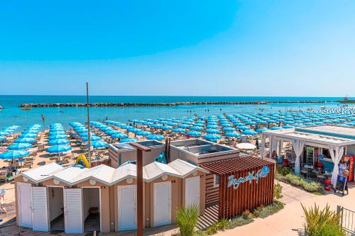 a beach with a lot of umbrellas and the ocean at Hotel Cola Frontemare in Bellaria-Igea Marina