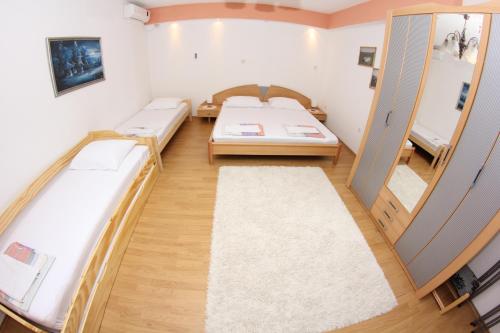 a room with two beds and a mirror at Apartment Kravica in Ljubuški
