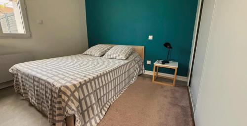een kleine slaapkamer met een bed en een blauwe muur bij Appartement La Gare-rdc in Saint-Gaudens