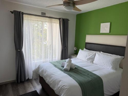 ein Schlafzimmer mit einem großen Bett mit einer grünen Wand in der Unterkunft 230 Laguna La Crete in Margate