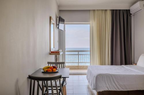 a hotel room with a bed and a bowl of fruit on a table at Vento di Mare in Perea